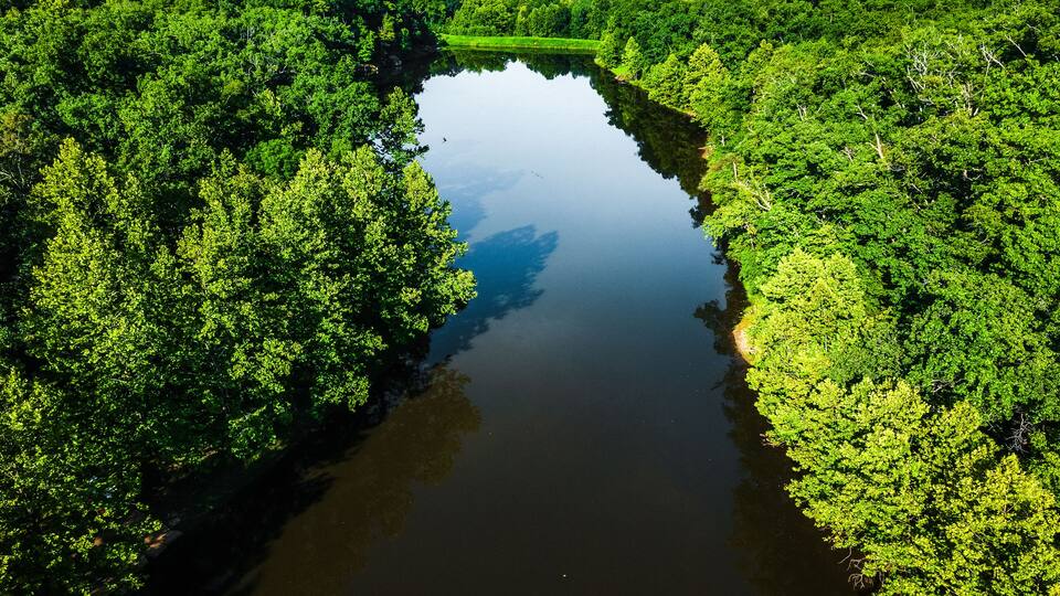 Birds-eye view of a beautiful small lake or pond in Innsbrook, Missouri on a summer day with water and green trees.