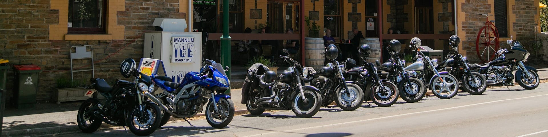 A building with a sign that reads "Mt Pleasant Hotel Motel." There are motorcycles parked in front of the building.