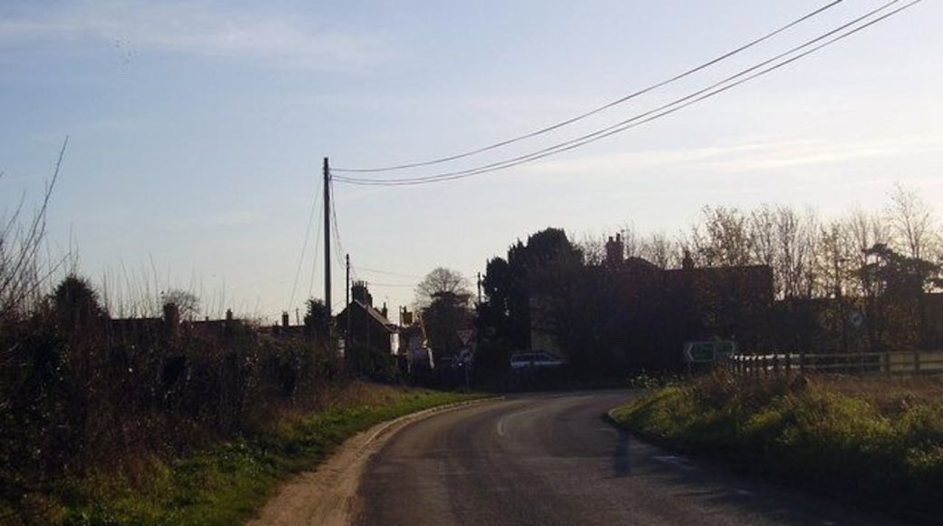 Hall road to Earsham. Looking at the site of the old level and crossing to Earsham Railway station 1431220. The A143 bypass used the trackbed of the closed line from Ditchingham to Redenhall. Back in the days of the station this was an untarmaced road. For a comparison view see Tivetshall to Beccles, The Waveney Valley Line from Middleton press ISBN 1 904474 41 1 available to buy or borrow from Norfolk Library service. Apologies if it is a dark picture, on my non internet connected laptop it is fine but on the old massive screen of the family computer it is very dark.