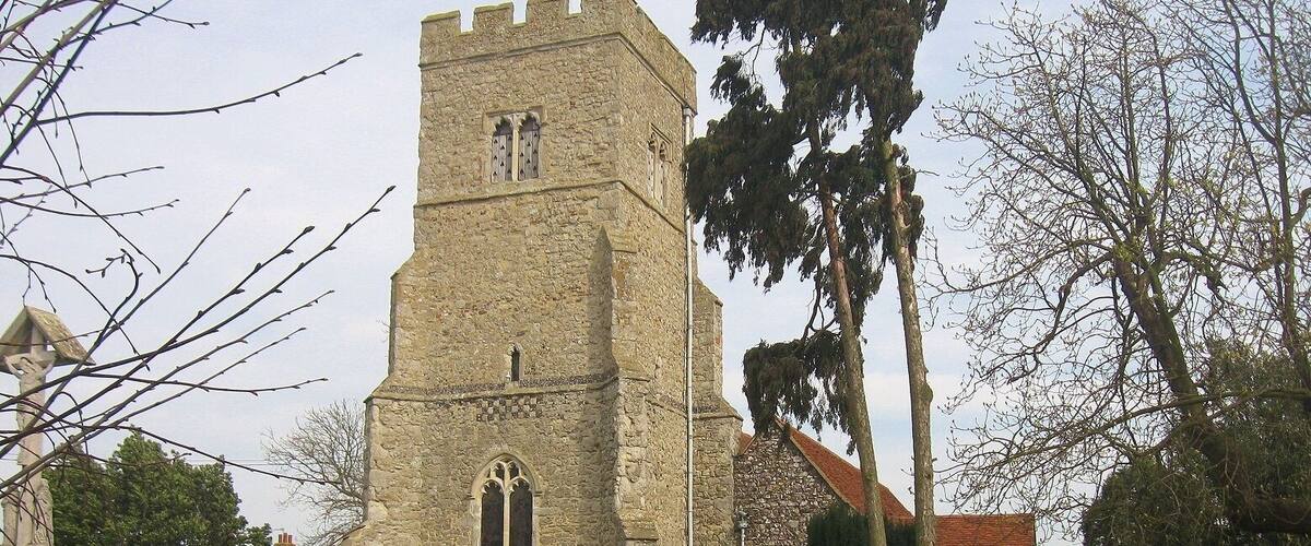 A stone church with a tall tower and arched windows.