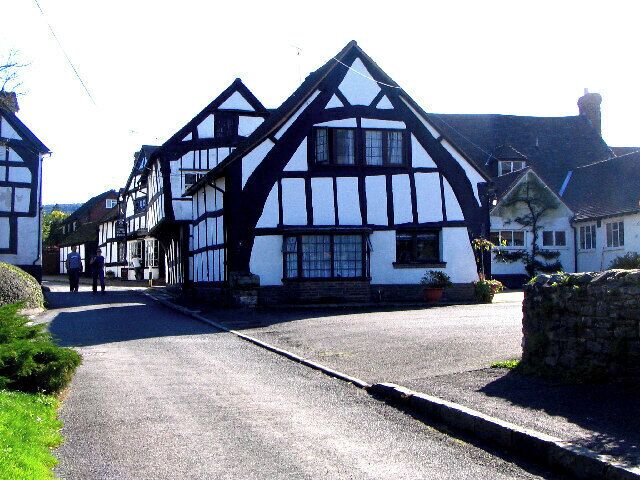 A traditional Tudor-style building with a steeply pitched roof and white and black timber framing.