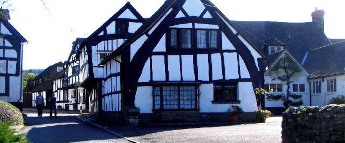 A traditional Tudor-style building with a steeply pitched roof and white and black timber framing.