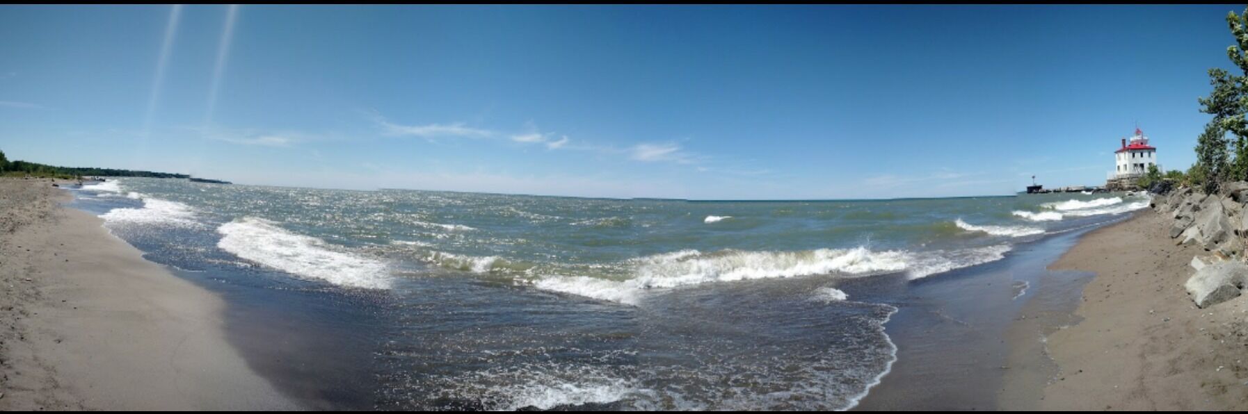 A panoramic view of the beach and light house. At over a mile in length, this is Ohio's largest beach. 