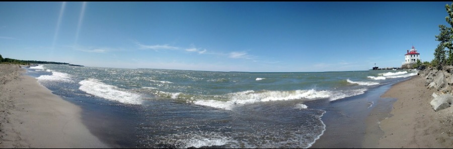 A panoramic view of the beach and light house. At over a mile in length, this is Ohio's largest beach.