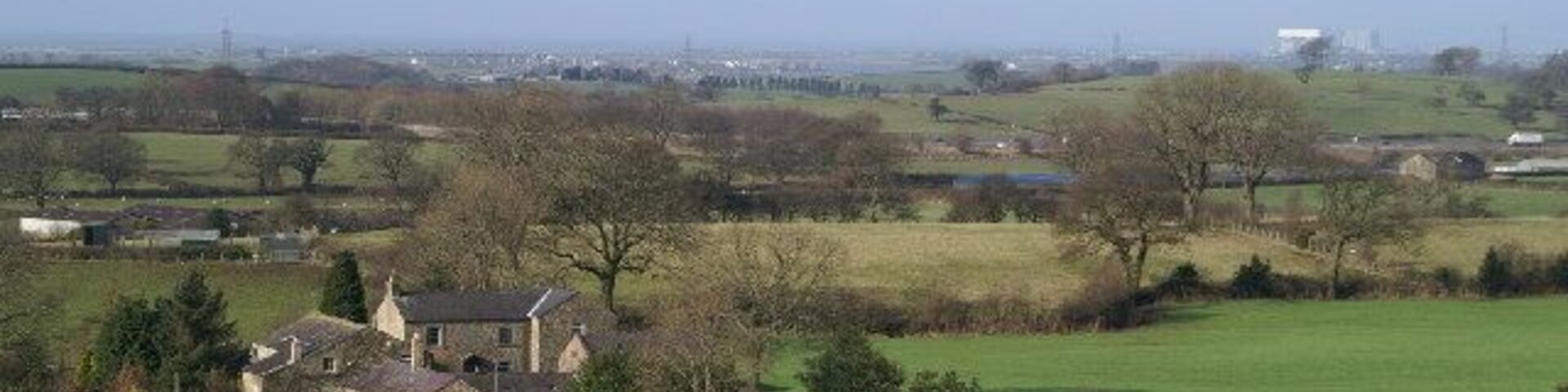 On a clear day. The white roof on the building in the distance, right, is Heysham Nuclear Power Station. The white lorry, extreme right, centre, is on the M6.