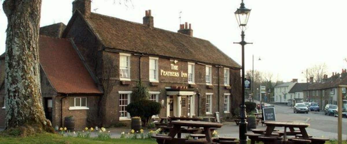 The Feathers Inn with outdoor seating and a lamp post.