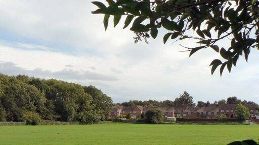 Across playing field to Beech Rise and Sleaford Wood