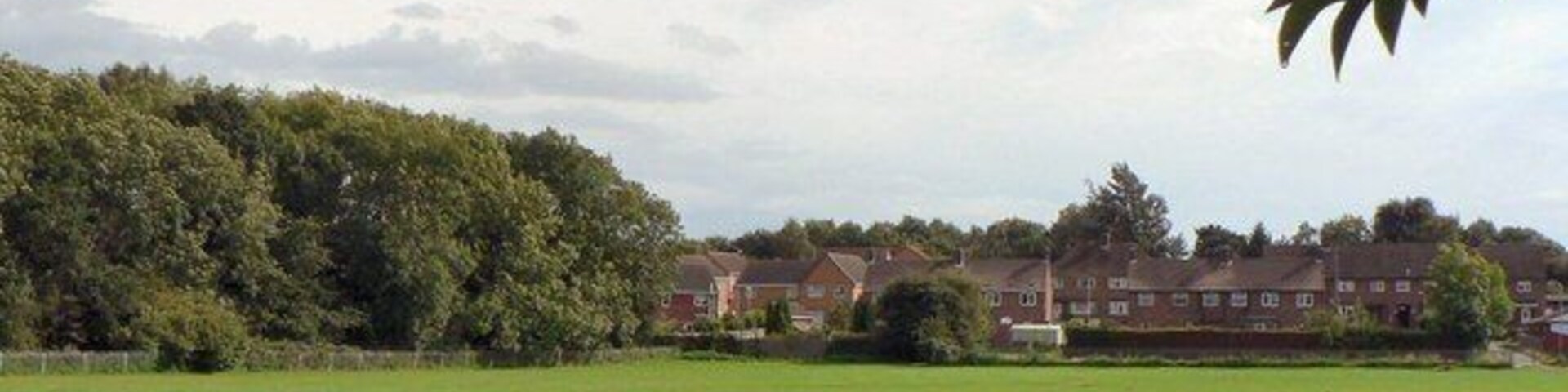 Across playing field to Beech Rise and Sleaford Wood