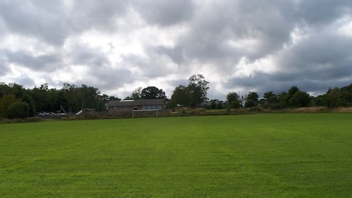The Football field And new sports pavilion in far distance in front of the trees.