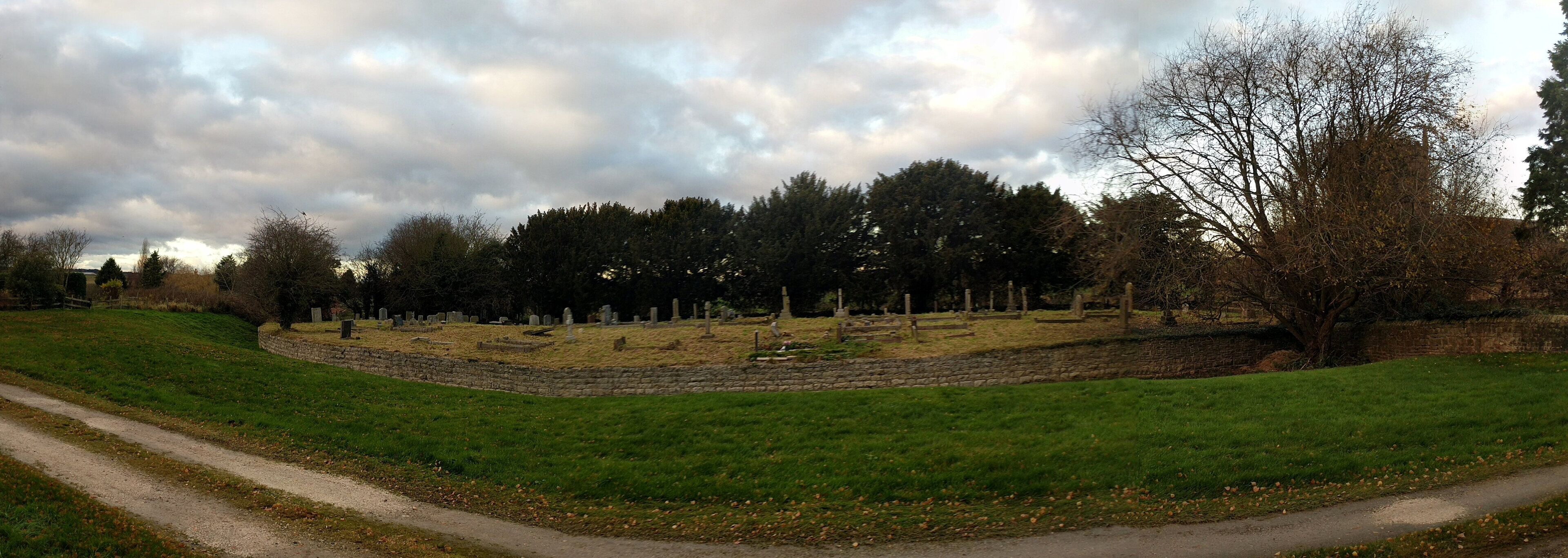 A cemetery with headstones and a path.