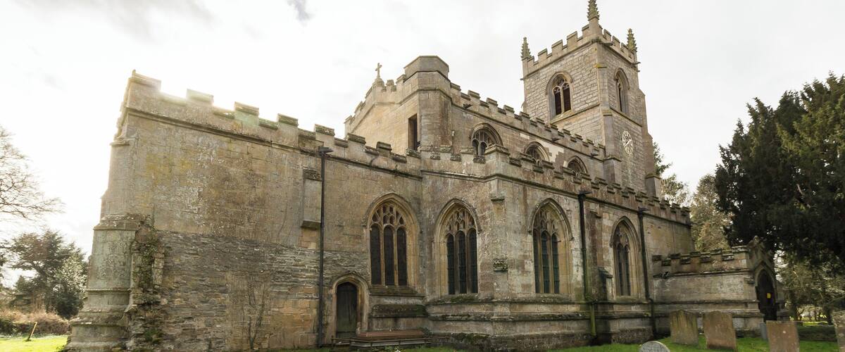 A historic stone church with a prominent tower and arched windows.
