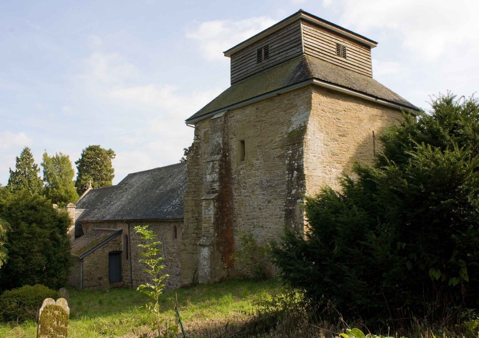 A stone building with a wooden tower and a small door.