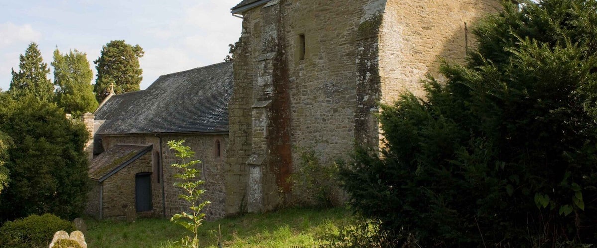 A stone building with a wooden tower and a small door.