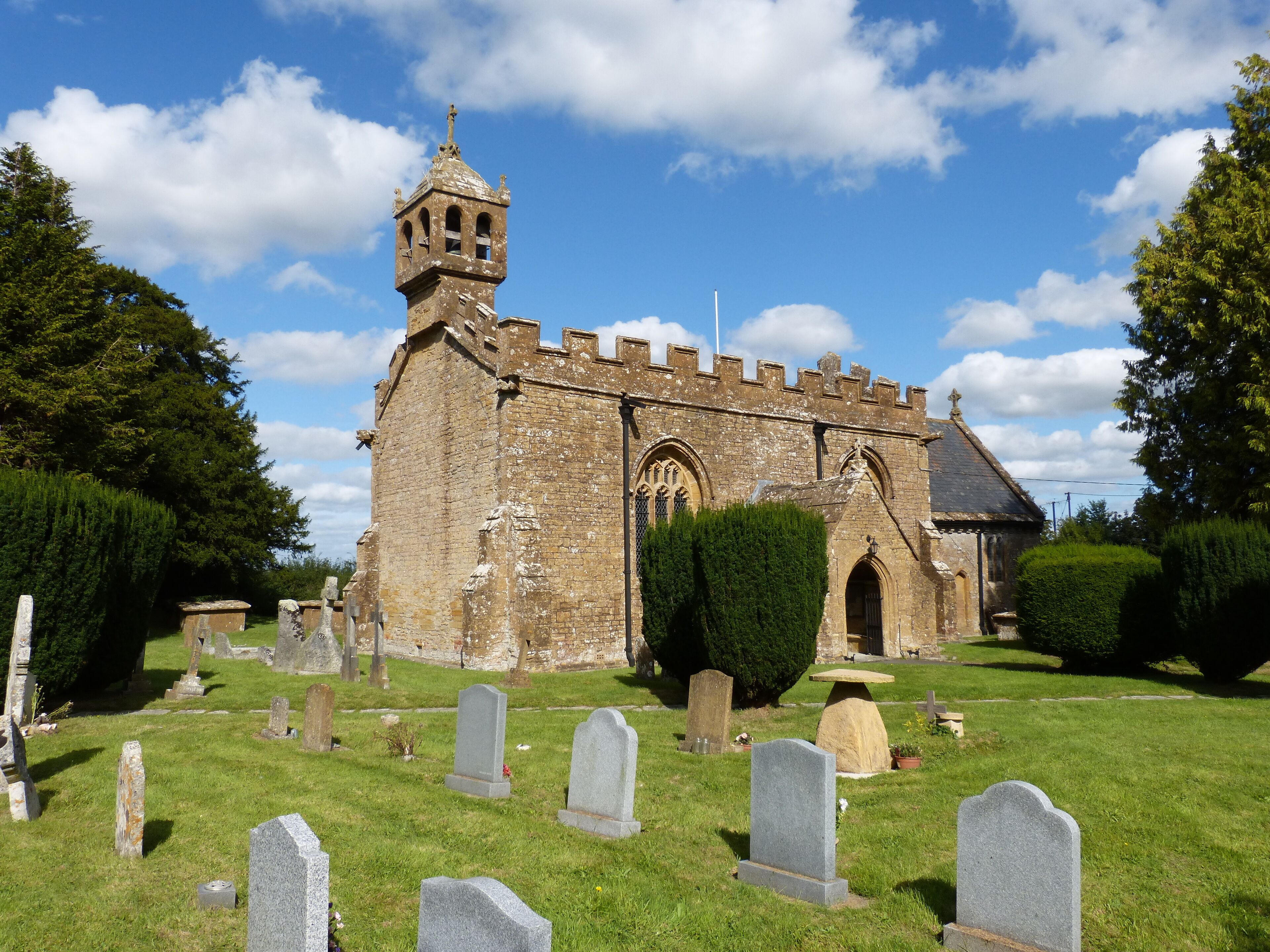 A historic church with a bell tower and a cemetery in front.