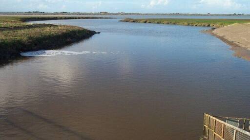The Huntspill River where it enters the Parrett Estuary Taken from the sluice gate, with the estuary of the River Parrett in the middle distance.