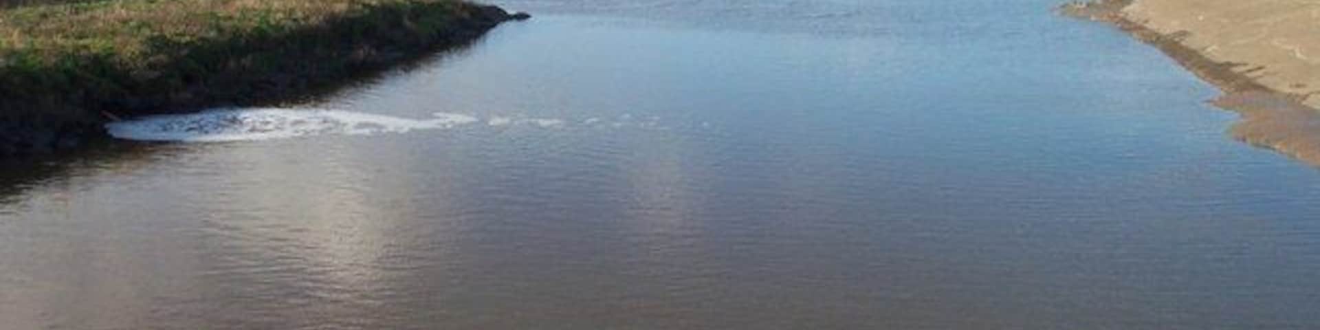 The Huntspill River where it enters the Parrett Estuary Taken from the sluice gate, with the estuary of the River Parrett in the middle distance.