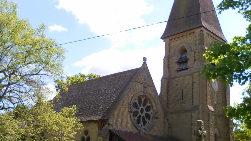 A church with a tall steeple and a large circular window.