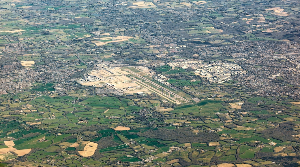 Une vue aérienne d’un paysage rural, avec des champs, une petite ville et une vaste zone ouverte comprenant des bâtiments.