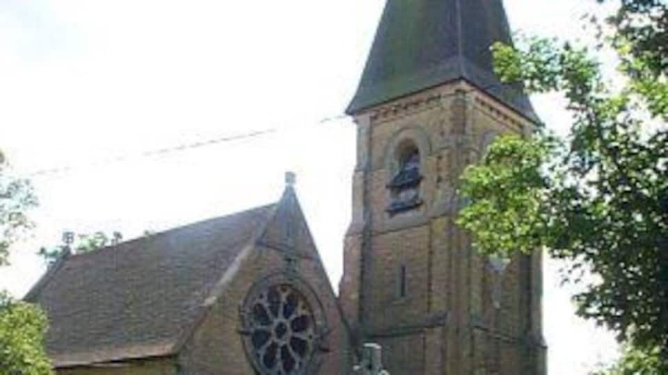A church with a tall steeple and a large circular window.