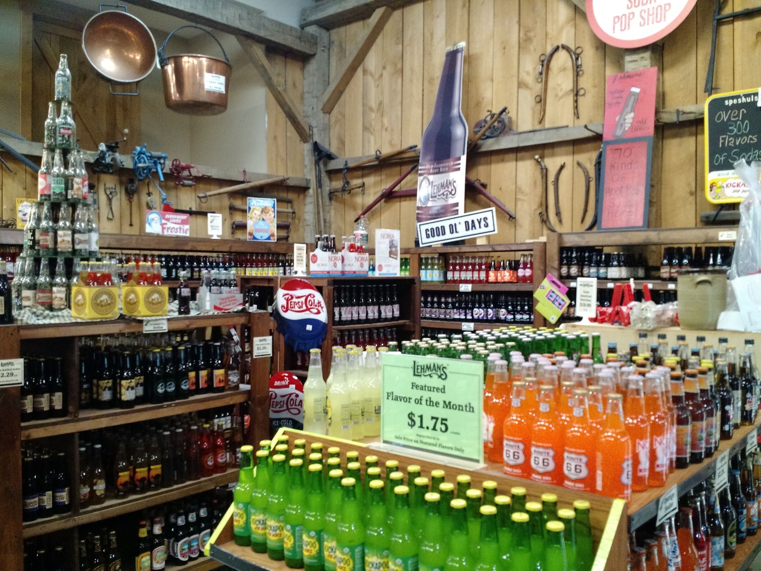 A store with shelves of beverages, a sign for Lehmans featured flavor, and a soda pop shop sign.