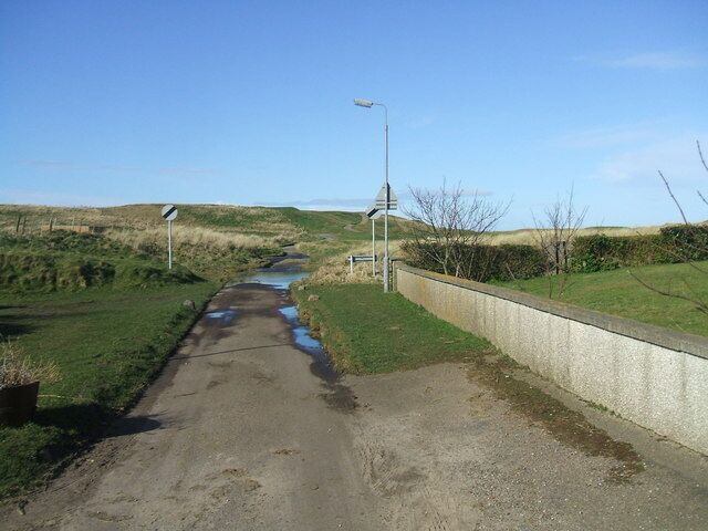 Coastal path out of St Combs It may be observed by the more cynical Geographer that the 'end of speed limit' signs are just a wee bit incongruous.