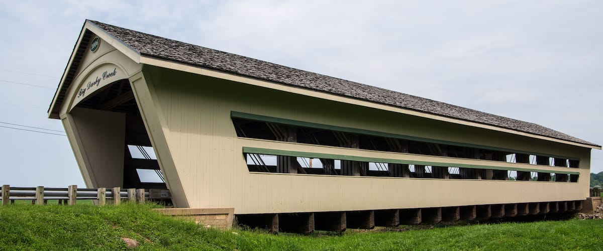 A large, single-story building with a slanted roof, labeled "Big Darby," situated on a grassy hill.