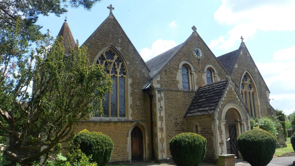 A historic church with pointed spires, large arched windows, and a clock.