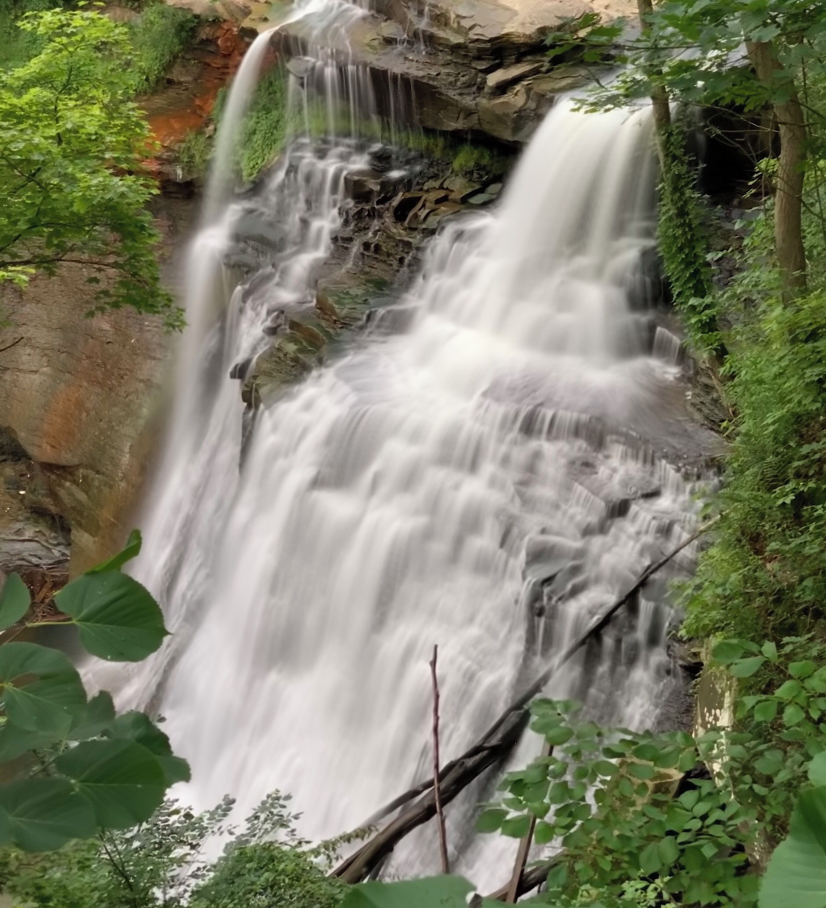#adventure
Carved by Brandywine Creek, the 65-foot falls demonstrates classic geological features of waterfalls. A layer of hard rock caps the waterfall, protecting softer layers of rock below. In this case, the top layer is Berea Sandstone. The softer layers include Bedford and Cleveland shales, soft rocks formed from mud found on the sea floor that covered this area 350-400 million years ago. Shale is thinly chunked, giving water a bridal veil appearance as it cascades down the falls.