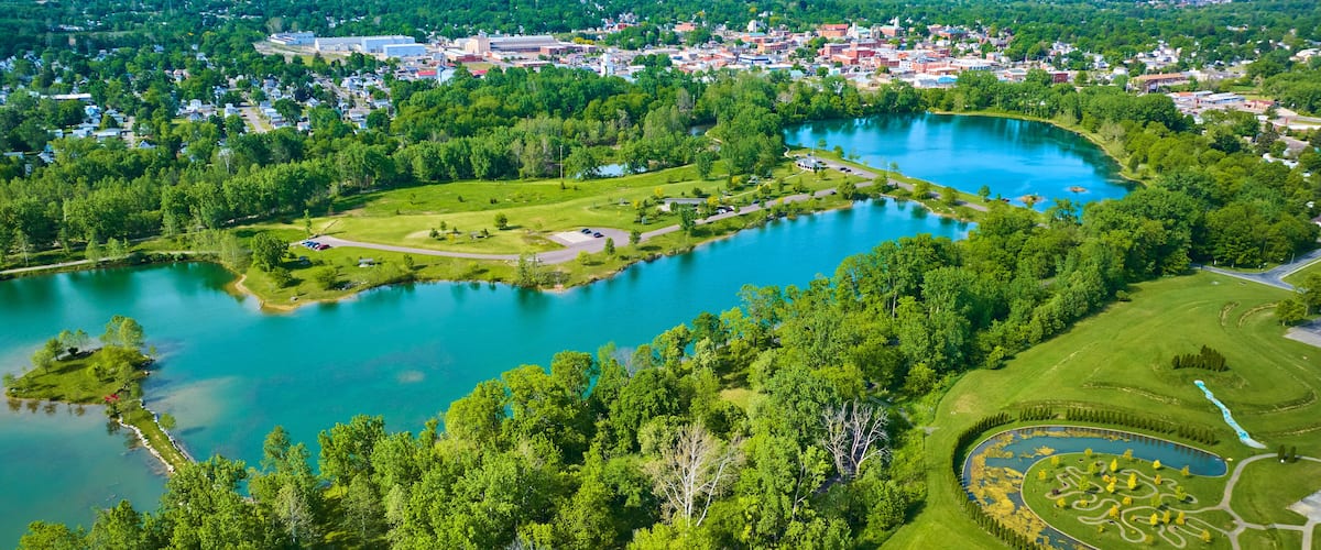 Distant city of Mount Vernon Ohio in aerial of large lake and island at Ariel Foundation Park trails