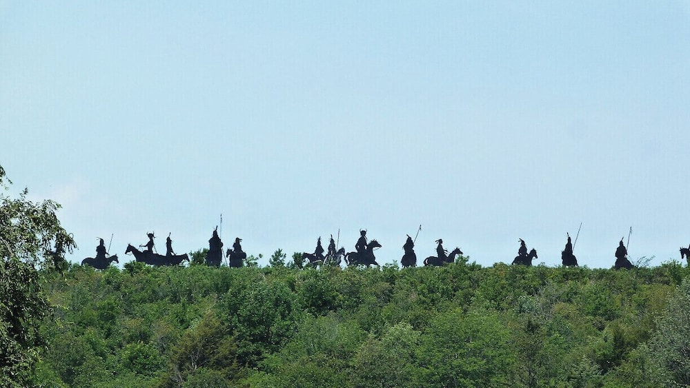 Eine Reigen von Reiterstatuen auf einem Hügel.