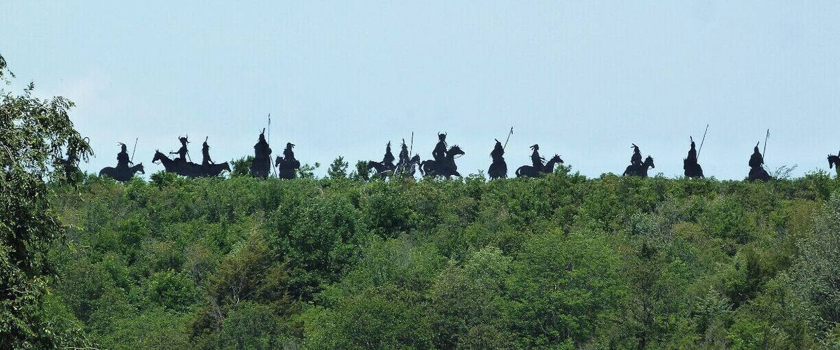 A line of equestrian statues on a hill.