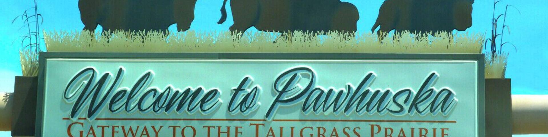 A sign with bison silhouettes and the text "Welcome to Pawhuska, Gateway to the Tallgrass Prairie."