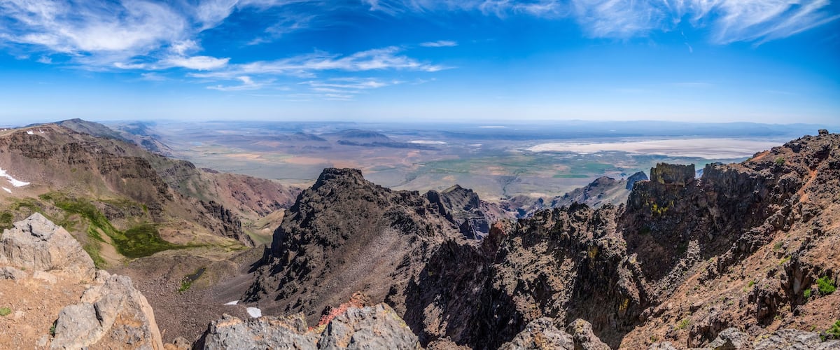 A mountainous landscape with rocky peaks and patches of snow.