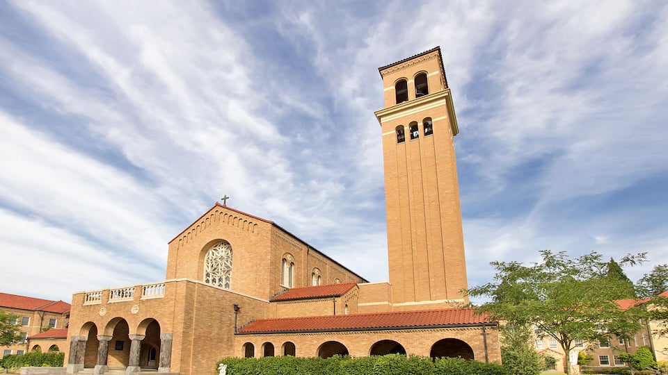 A large brick church with a tall tower and arched windows.