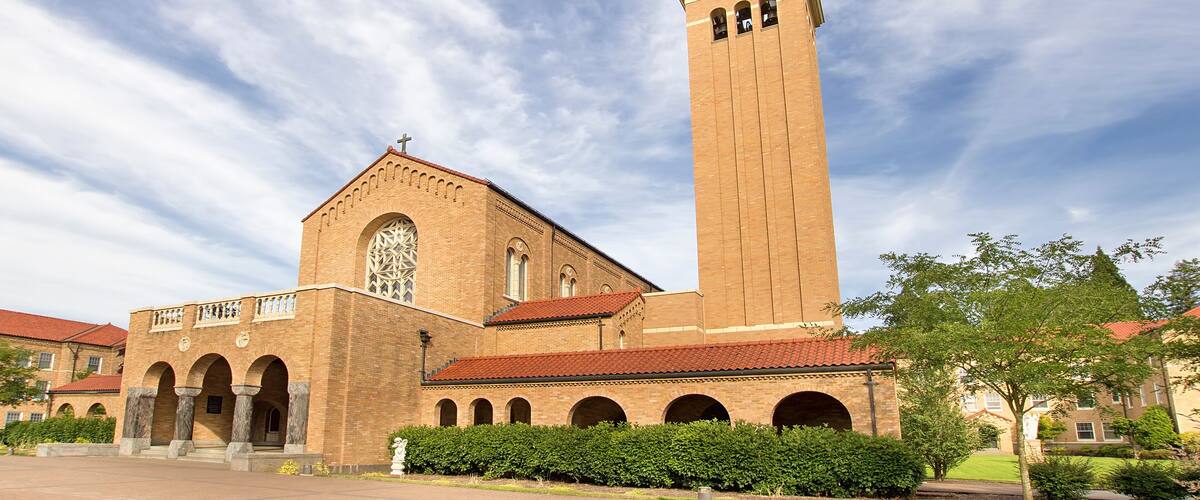 A large brick church with a tall tower and arched windows.