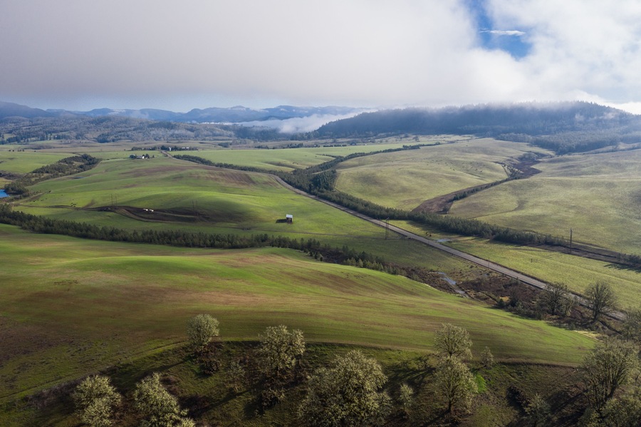 A low blanket of clouds drifts slowly over the rural landscape of central Oregon. This beautiful region is known for its extensive farming and nearby logging communities.
