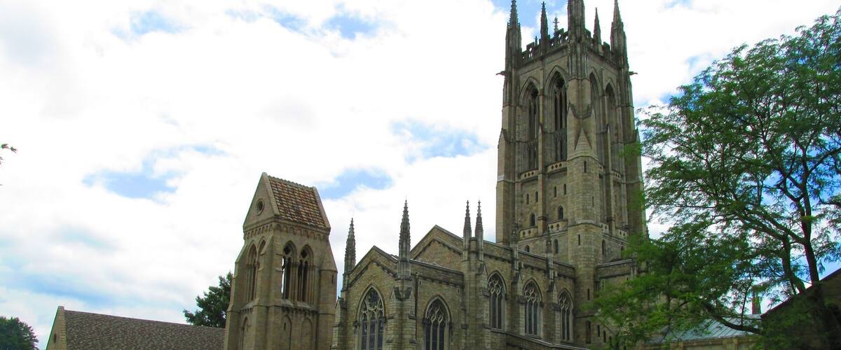 A historic cathedral with a tall tower and a smaller adjacent building.