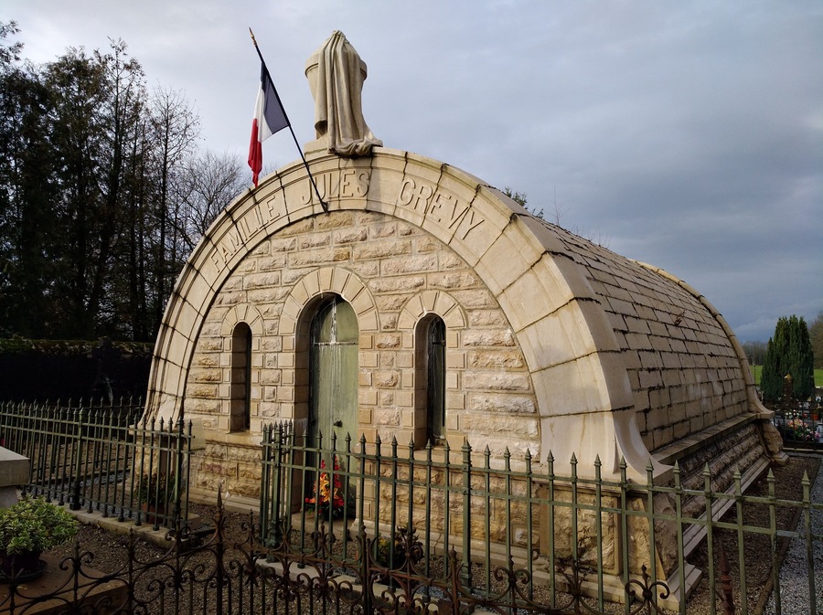 Un edificio de piedra con una entrada arqueada y un asta de bandera.