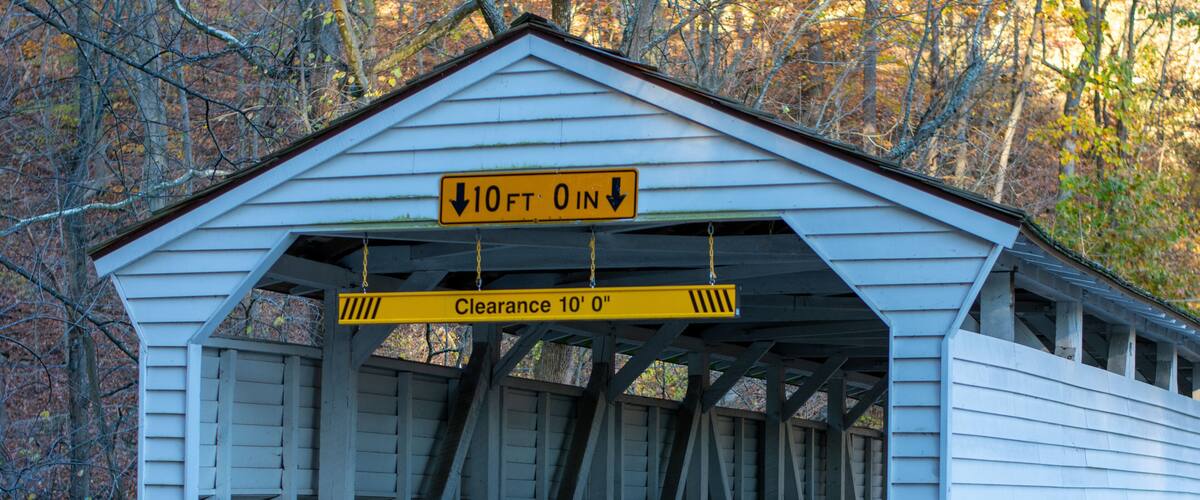 A covered bridge with a sign indicating a 10-foot clearance.