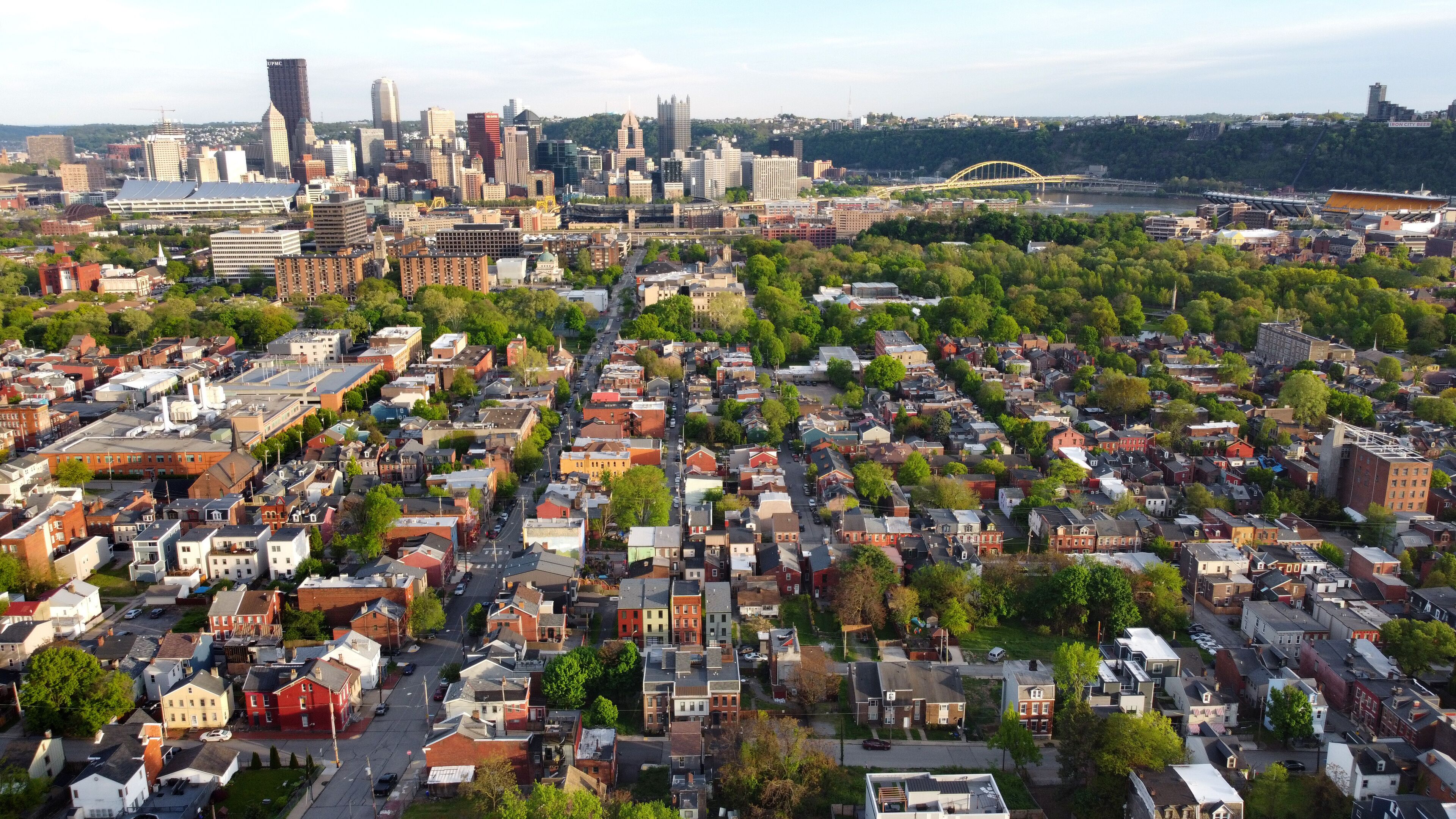 A cityscape with dense urban housing, a prominent bridge, and a skyline with high-rise buildings.