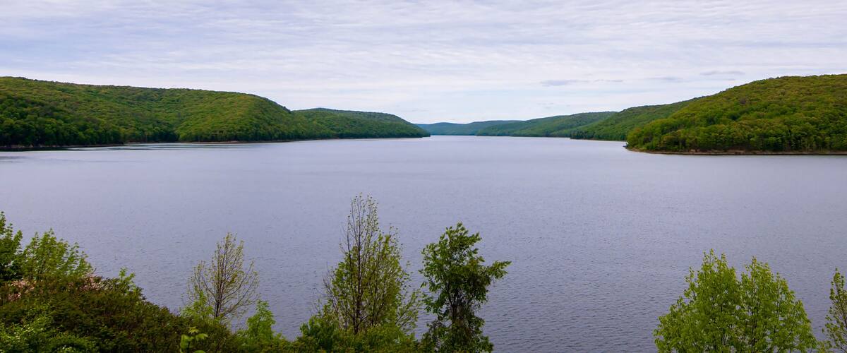 A calm lake surrounded by lush green hills.