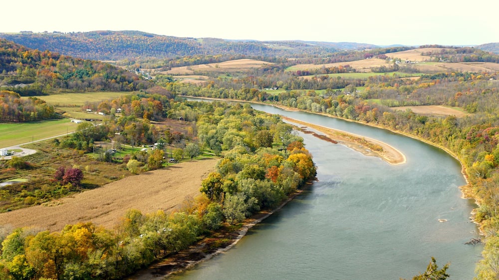 The aerial view of the Susquehanna River surrounded by striking color of fall foliage near Wyalusing, Pennsylvania, U.S