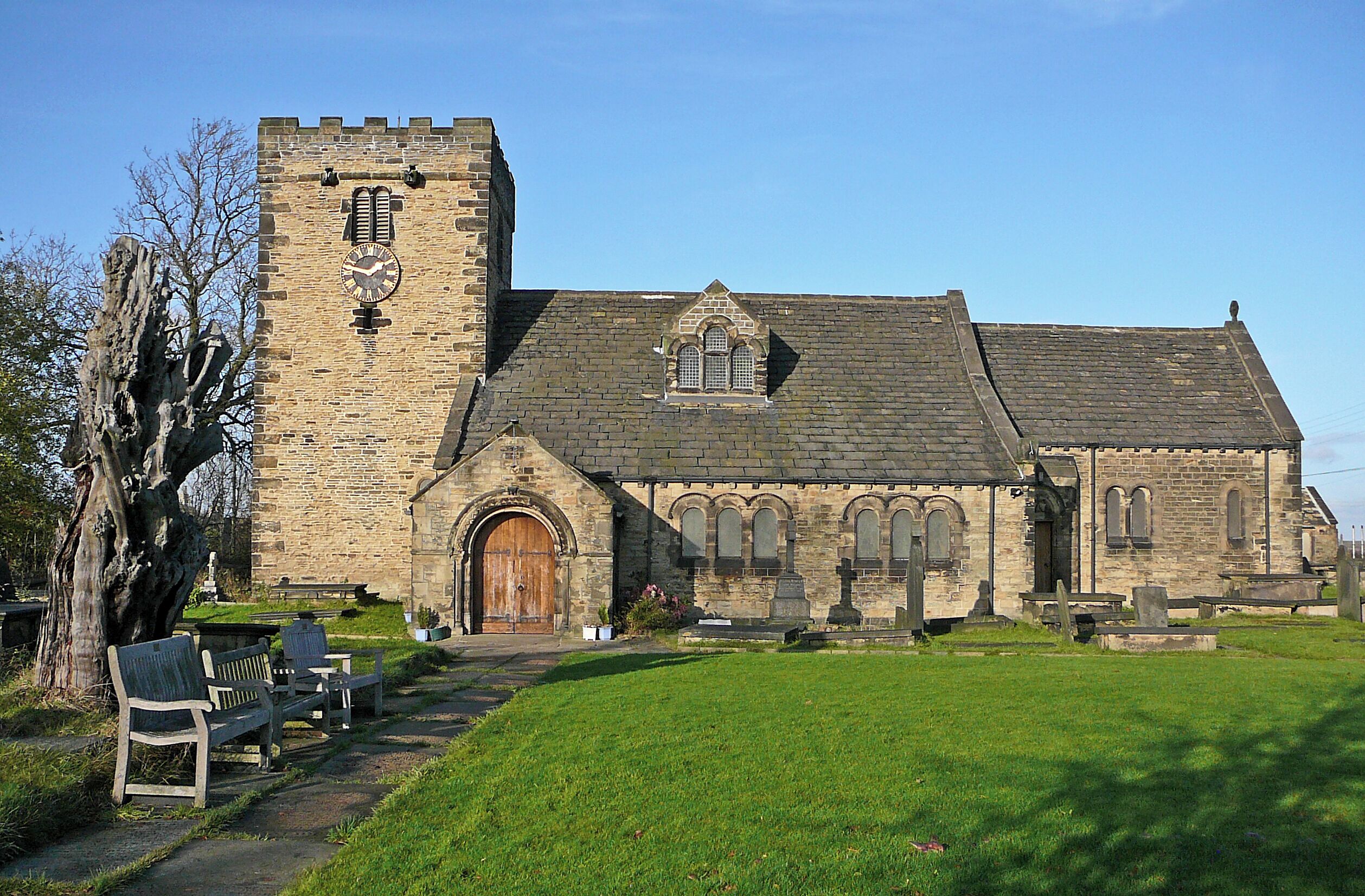 A historic stone church with a prominent tower and arched windows.