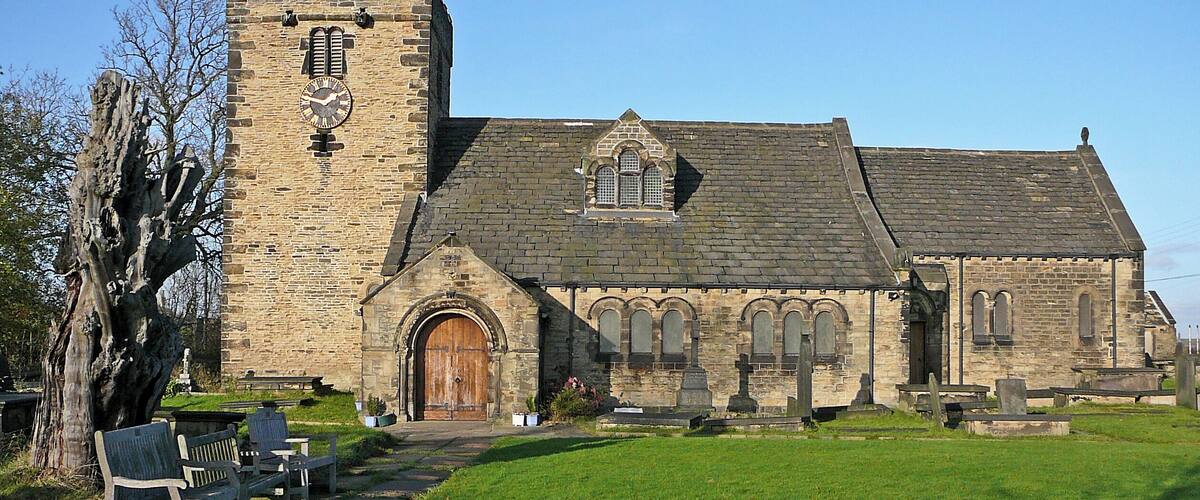 A historic stone church with a prominent tower and arched windows.