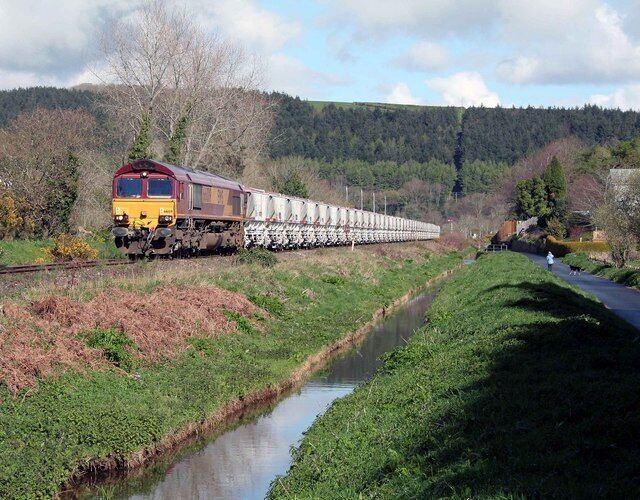 Clay from Rocks for Fowey Docks 66009 hauls the clay for export from Fowey Docks at St Blazey by the canal in the morning sun.