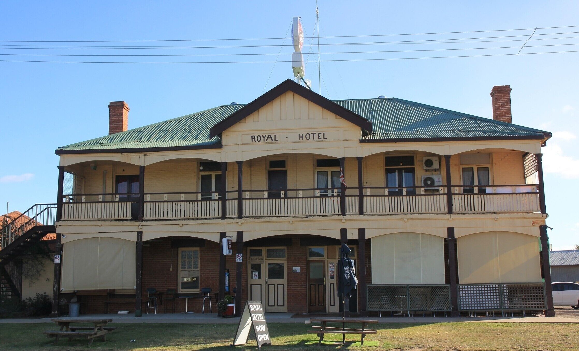 A two-story building with a sign reading "ROYAL HOTEL" and a balcony.