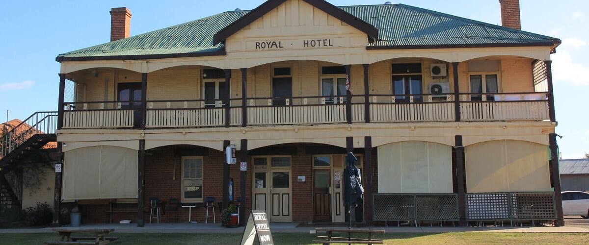A two-story building with a sign reading "ROYAL HOTEL" and a balcony.
