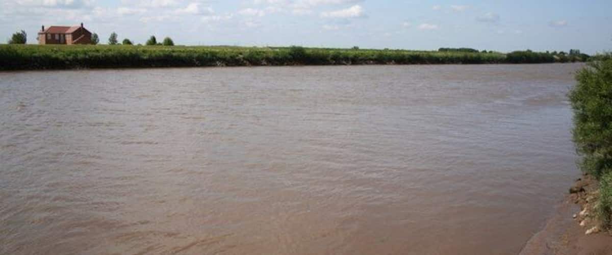 A river with a house on the left bank.