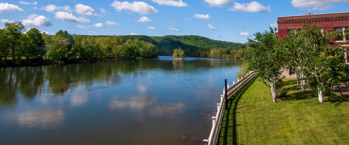 The Allegheny River in Warren, Pennsylvania, USA in springtime under bright blue skies with white clouds