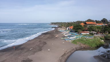 A beach with boats, a sandy shore, and buildings in the background.